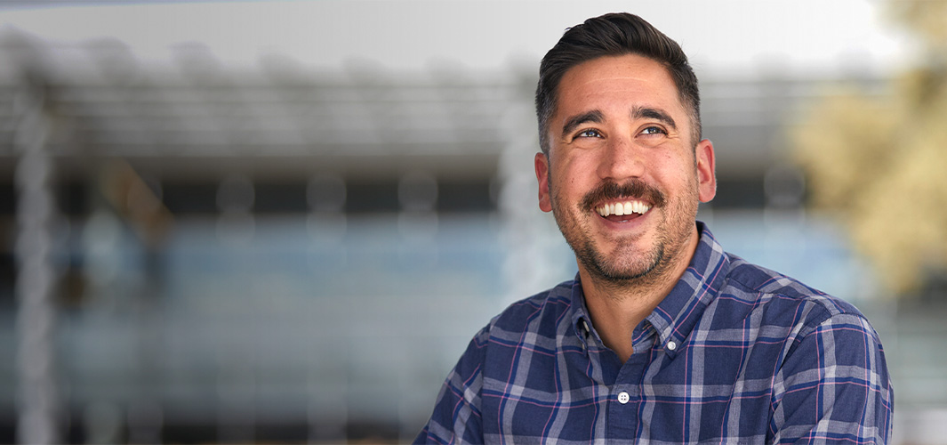 Marc olha para o lado com um largo sorriso.