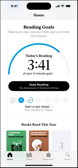 Layar iPhone memperlihatkan antarmuka Target Bacaan di aplikasi Books. Di bagian atas, terdapat lingkaran kemajuan. Di bawah lingkaran kemajuan terdapat pelacak riwayat bacaan mingguan. Di bagian bawah terdapat bagian Buku yang Dibaca Tahun Ini, yang mencakup deretan dua buku, dengan tempat kosong untuk buku ketiga