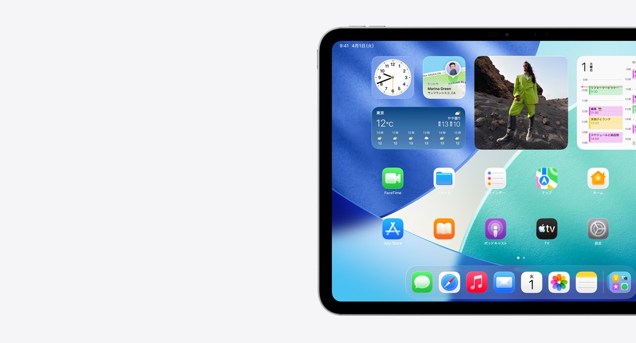 横向きのiPad。画面の左側のみが見えている。Liquid Glassのエフェクトを持つ半透明の時計などを含むウィジェットスタック、「探す」アプリ、天気ウィジェット、2列に並んだ小さなアプリ、Dockがホーム画面に表示されている