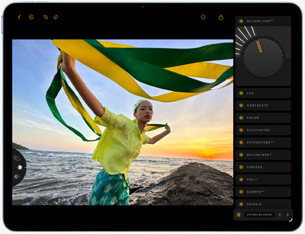 iPad Air, parte frontal, edición de fotografía de una persona con una tela verde y amarilla sobre un fondo de playa al atardecer, con herramientas de edición visibles del lado derecho