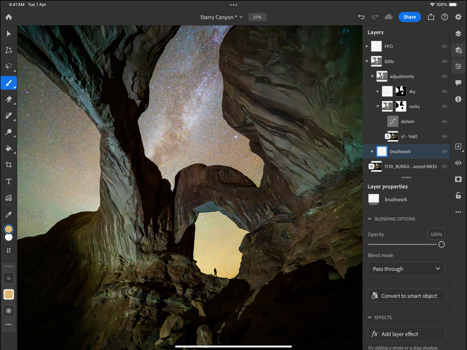 iPad Pro, front exterior, landscape orientation, space black color, rounded corners, black display bezel, display showing a photograph being edited of a canyon and a star filled night sky, at right, editing layers, tools, and effects visible including brushwork, adjustments, and others