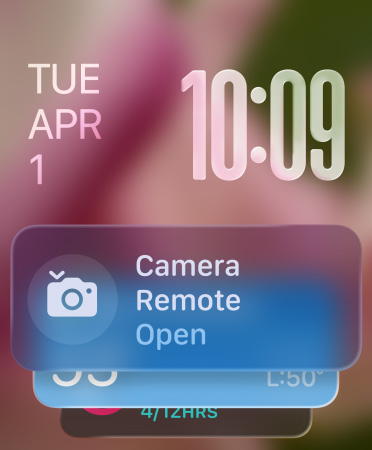 Das Widget für die Kamerafernbedienung erscheint unten auf dem Bildschirm, oben rechts sind transluzente Zeitziffern zu sehen, das Datum befindet sich oben links