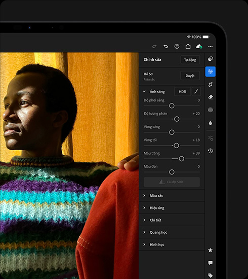 iPad Pro, vỏ ngoài mặt trước, nằm ngang, màu đen không gian, màn hình hiển thị ảnh chụp một người mặc áo len đầy màu sắc đang được chỉnh sửa, menu công cụ và hiệu ứng đang mở ở bên phải